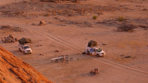 Eine Übernachtung am Fuss eines Berges bei Sonnenuntergang, Das Lager wird eigerichtet. Offroad Namibia | © 4x4 Exploring GmbH