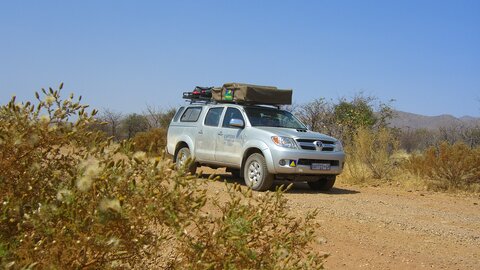 Ein Allradfahrzeug fährt durch das unwegsame Gelände. Offroad Namibia | © 4x4 Exploring GmbH