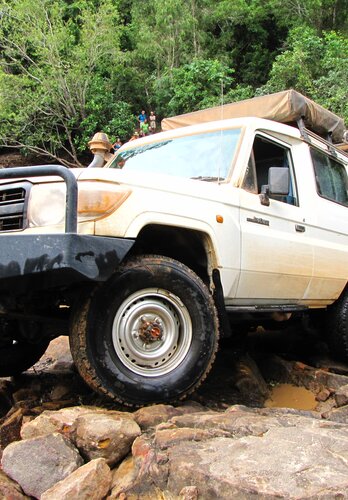 Knackige Offroad Passagen | © 4x4 Exploring GmbH Ein Allradfahrzeug aus einem Flussbett kommend, erklimmt grosse Felsbrocken. Offroad Cape York Australien | © 4x4 Exploring GmbH