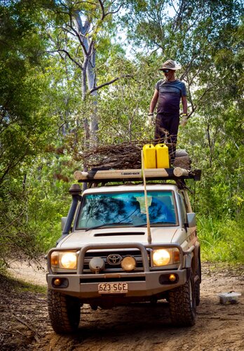 Ein Mann befestigt auf dem Dach seines Allradfahrzeuges das Brennholz für den nächsten Lager. Offroad Cape York Australien | © 4x4 Exploring GmbH