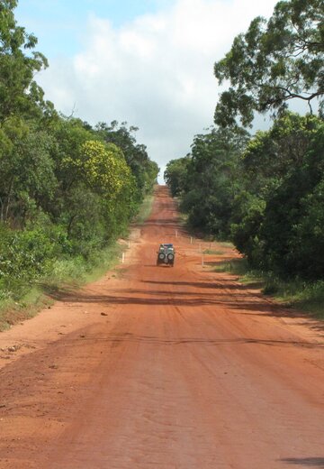 Ein Allradfahrzeug passiert ein breiten unbefestigten Wegabschnitt. Der Boden ist rot. Offroad Cape York Australien | © 4x4 Exploring GmbH